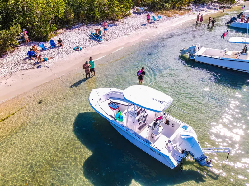 Slide: The Image of 2023 Tidewater 220 CC Adventure boat on calm water with clear blue sky. - 10