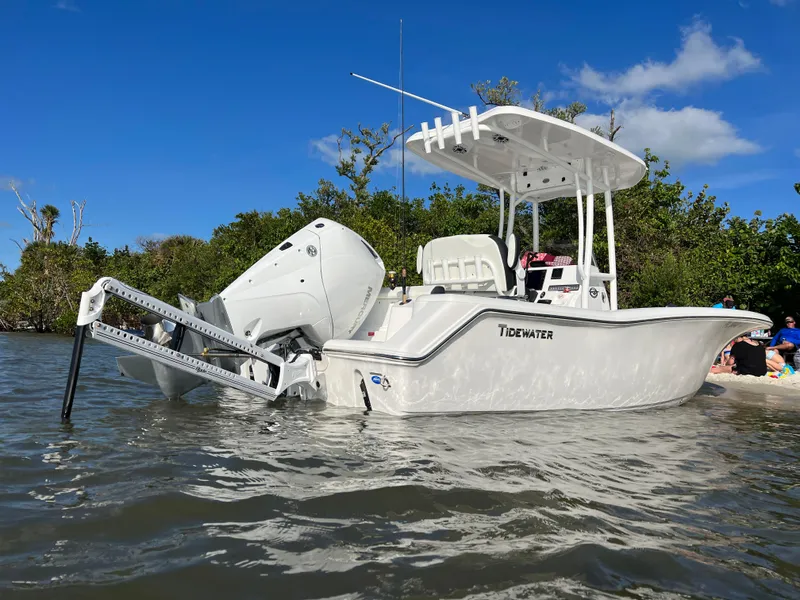 Slide: The Image of 2023 Tidewater 220 CC Adventure boat on water with Mercury engine. - 2