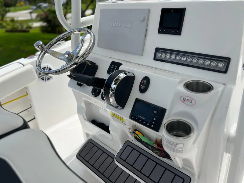 Slide: The Image of Control panel of 2023 Tidewater 220 CC Adventure boat with switches and cup holder. - 21