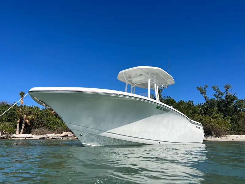 Slide: The Image of 2023 Tidewater 220 CC Adventure boat on calm water under a blue sky. - 5