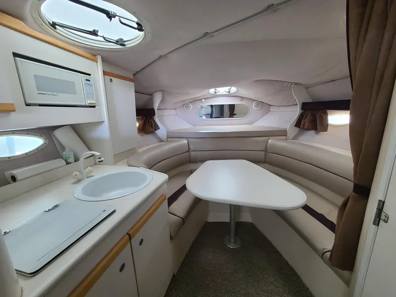 Slide: The Image of 1995 Cruisers Rogue boat interior with kitchenette and dining area. - 14