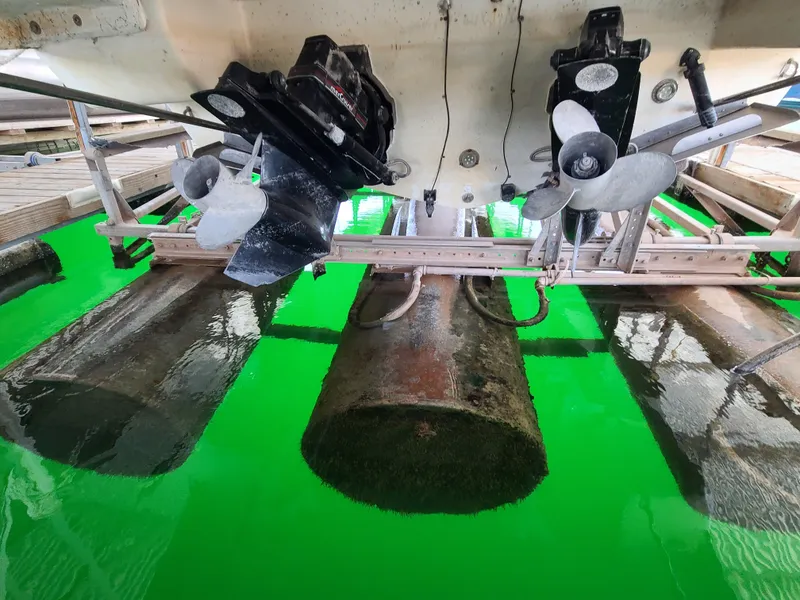 Slide: The Image of 1995 Cruisers Rogue boat propellers and hull in dry dock with green water reflection. - 20
