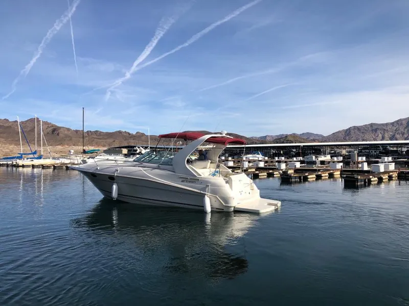 Slide: The Image of 1995 Cruisers Rogue boat docked in a marina with clear skies and mountains. - 24