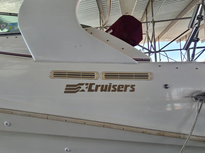 Slide: The Image of 1995 Cruisers Rogue boat docked under a metal canopy. - 4