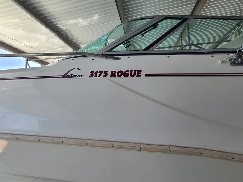 Slide: The Image of 1995 Cruisers Rogue 3175 boat under a metal canopy. - 5