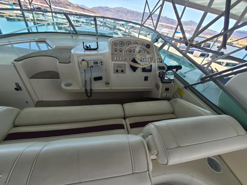 Slide: The Image of 1995 Cruisers Rogue boat helm with white leather seating and control panel. - 7