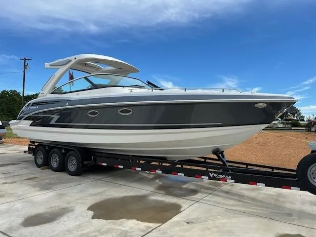 Slide: The Image of 2025 Formula 330 Crossover Bowrider I/O on trailer, sleek design, blue sky background. - 3