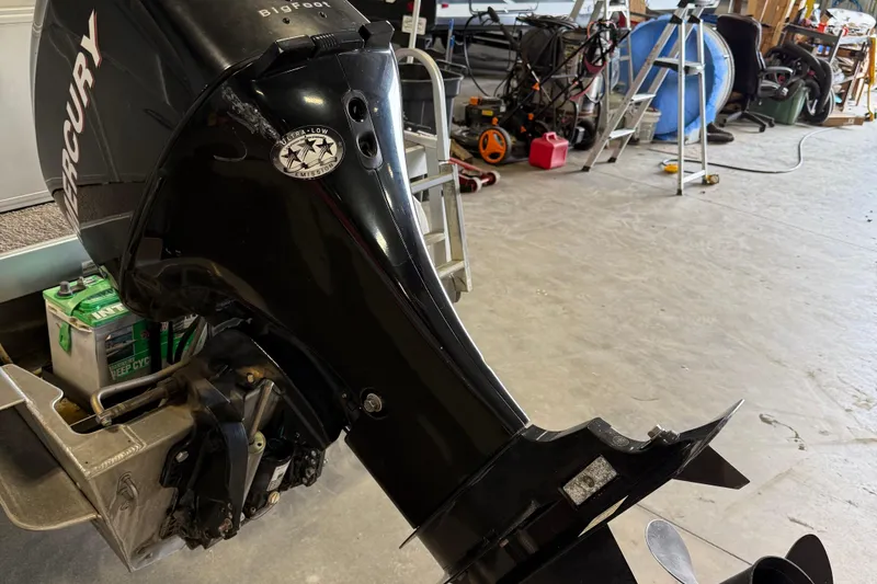 Slide: The Image of 2007 Crestliner 2185 Batata Bay with Mercury outboard motor in a garage setting. - 5