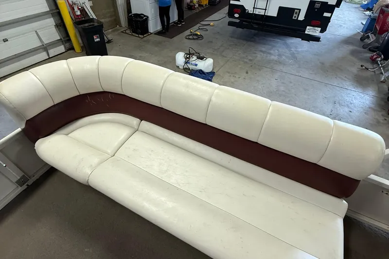 Slide: The Image of 2007 Crestliner 2185 Batata Bay boat interior with white and maroon seating in a garage. - 7