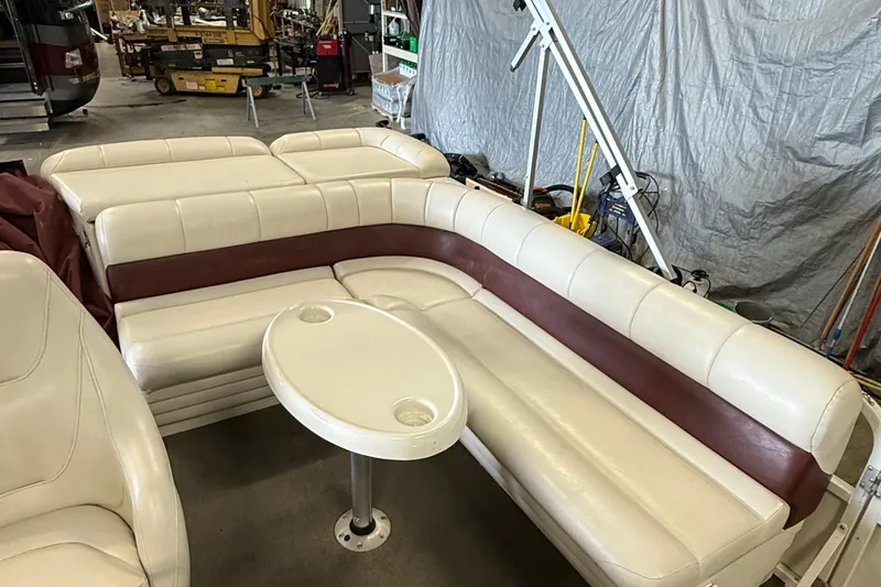 Slide: The Image of 2007 Crestliner 2185 Batata Bay boat interior with white and maroon seating, small table. - 9