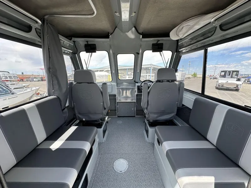 Slide: The Image of Interior of 2024 Hewescraft 240 Ocean Pro ET boat with gray seating and large windows. - 5