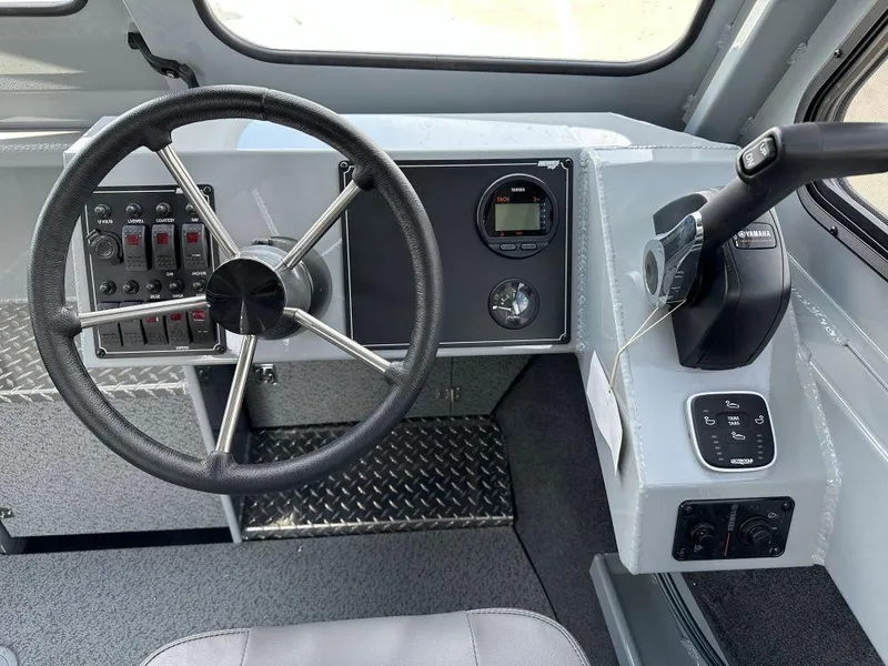 Slide: The Image of 2024 Hewescraft 240 Ocean Pro ET boat helm with steering wheel and control panel. - 6
