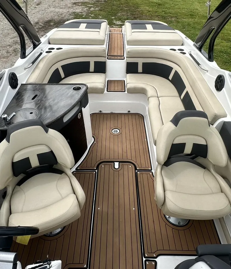 Slide: The Image of 2018 Rinker QX29 BR boat interior with beige seating and wooden flooring. - 11