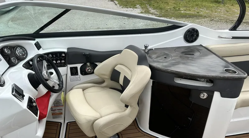 Slide: The Image of 2018 Rinker QX29 BR boat cockpit with steering wheel and captain's chair. - 13