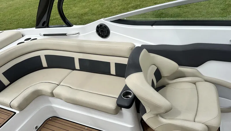 Slide: The Image of 2018 Rinker QX29 BR boat interior with beige and black seating. - 14