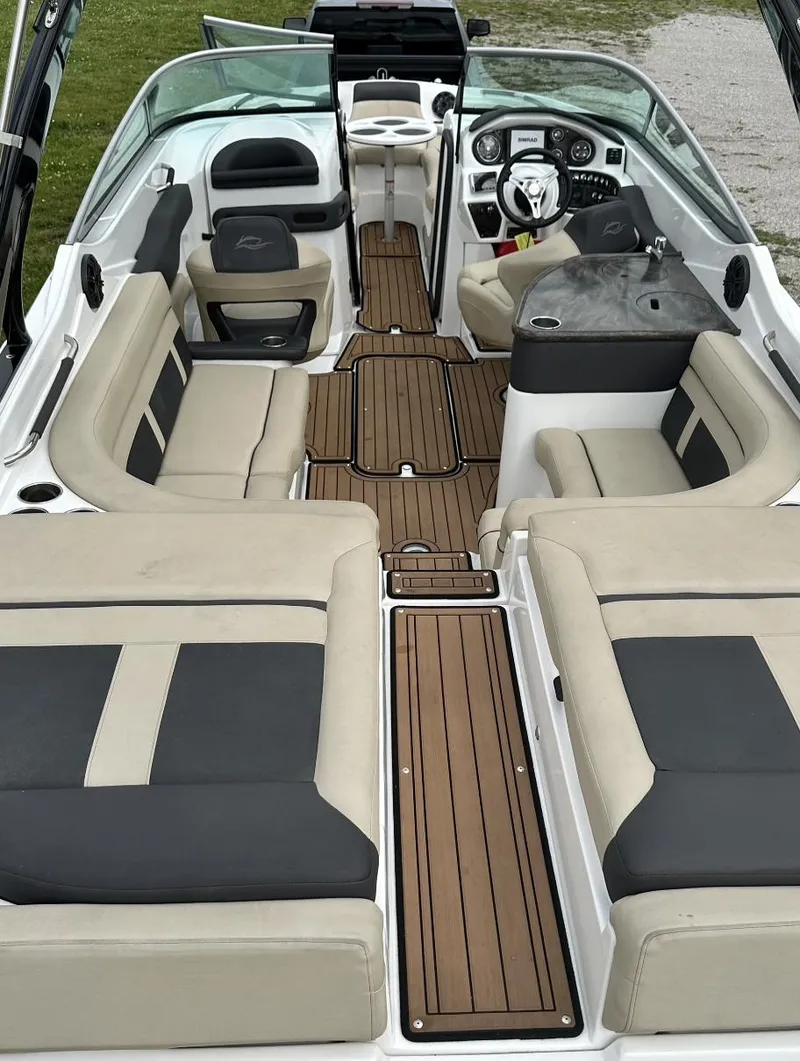 Slide: The Image of 2018 Rinker QX29 BR boat interior with beige and black seating. - 15