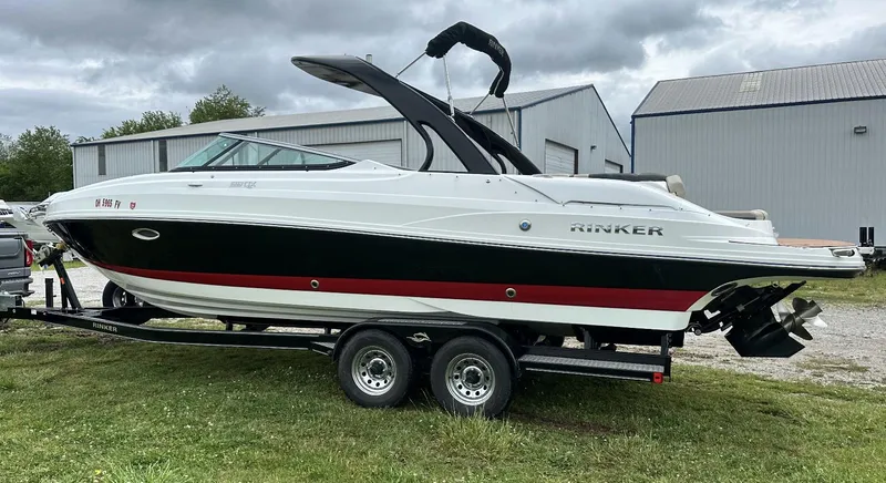 Slide: The Image of 2018 Rinker QX29 BR boat on a trailer outside a warehouse. - 4