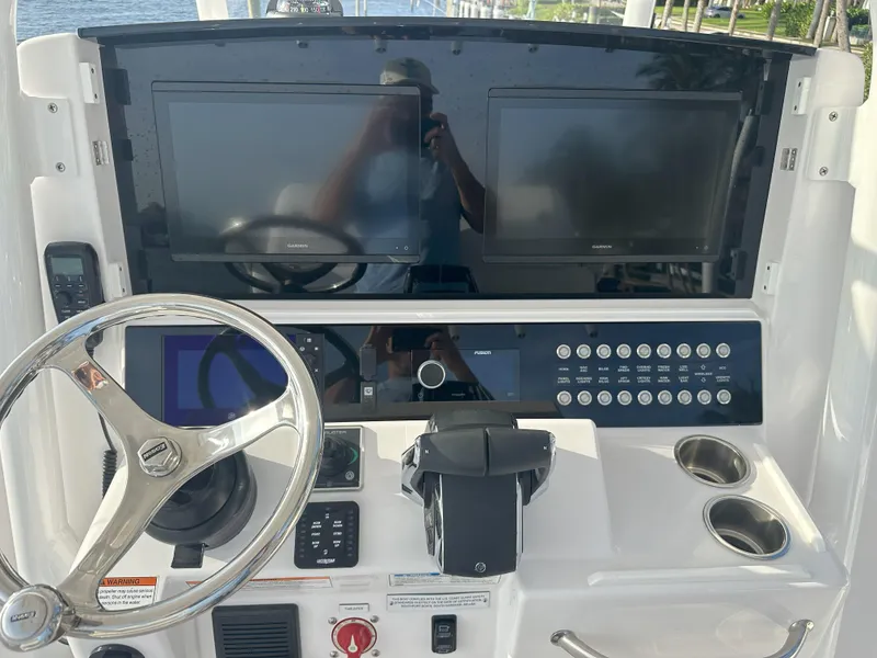 Slide: The Image of 2024 Southport 30 FE boat dashboard with dual screens and steering wheel. - 11