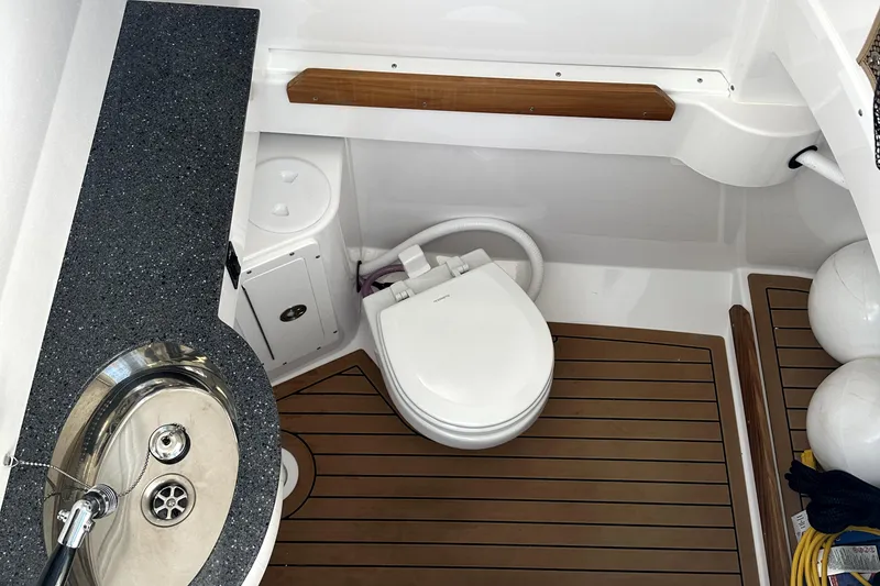 Slide: The Image of 2024 Southport 30 FE boat bathroom with sink, toilet, and wooden flooring. - 19