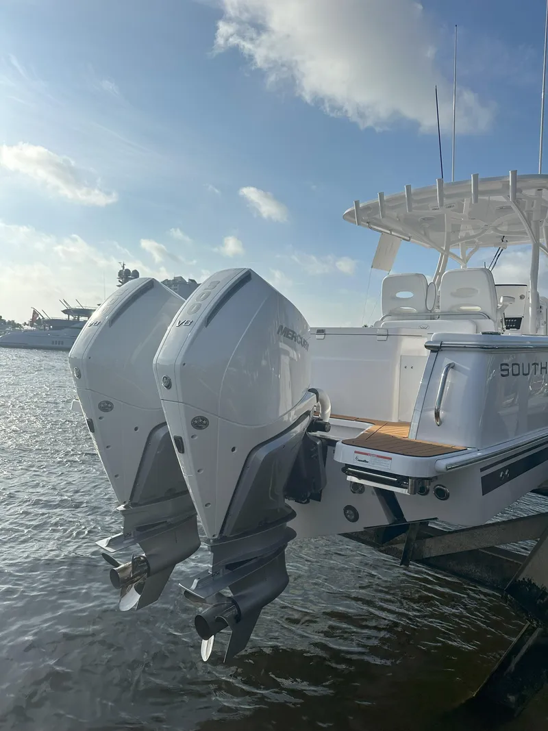 Slide: The Image of 2024 Southport 30 FE boat with twin outboard engines docked on water. - 2