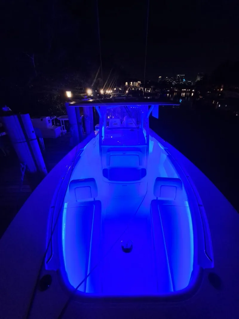 Slide: The Image of 2024 Southport 30 FE boat illuminated with blue LED lights at night. - 33