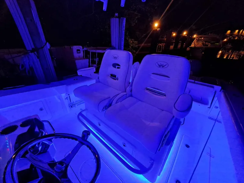 Slide: The Image of 2024 Southport 30 FE boat interior with illuminated captain's chairs at night. - 35