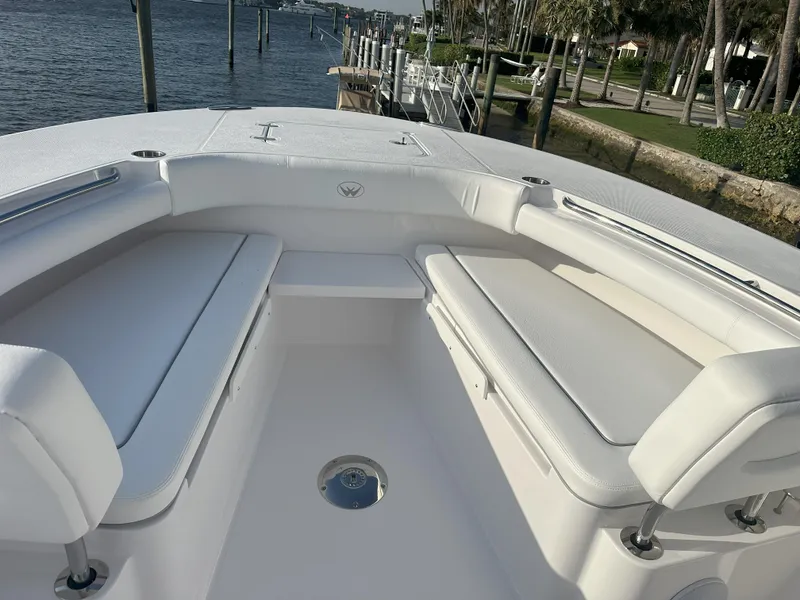 Slide: The Image of 2024 Southport 30 FE boat with white cushioned seating, docked by the waterfront. - 5