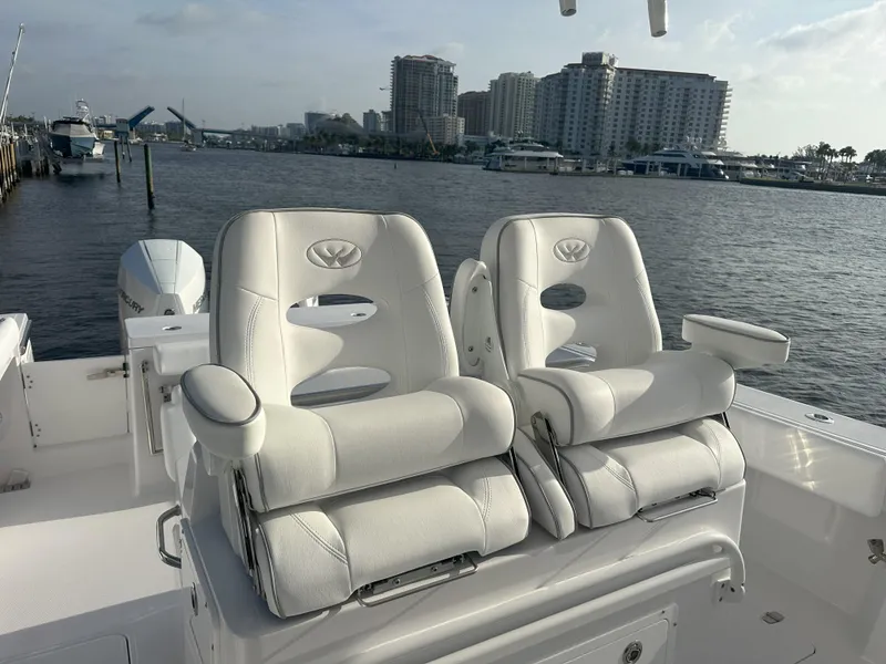 Slide: The Image of 2024 Southport 30 FE boat with luxurious white seating, docked near waterfront buildings. - 8