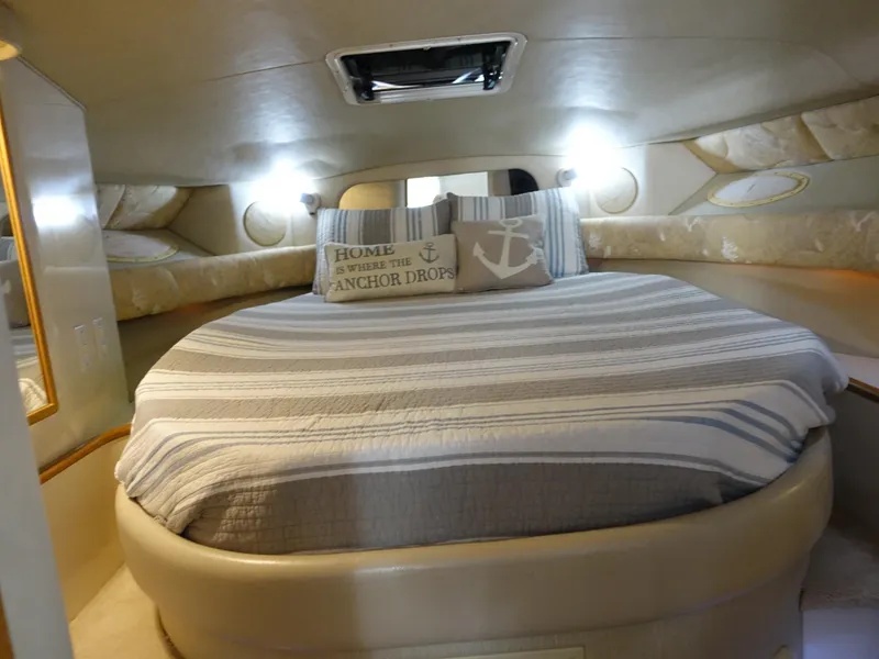 Slide: The Image of Cozy cabin interior of 1996 Sea Ray 370 Sundancer with striped bedding and nautical decor. - 12