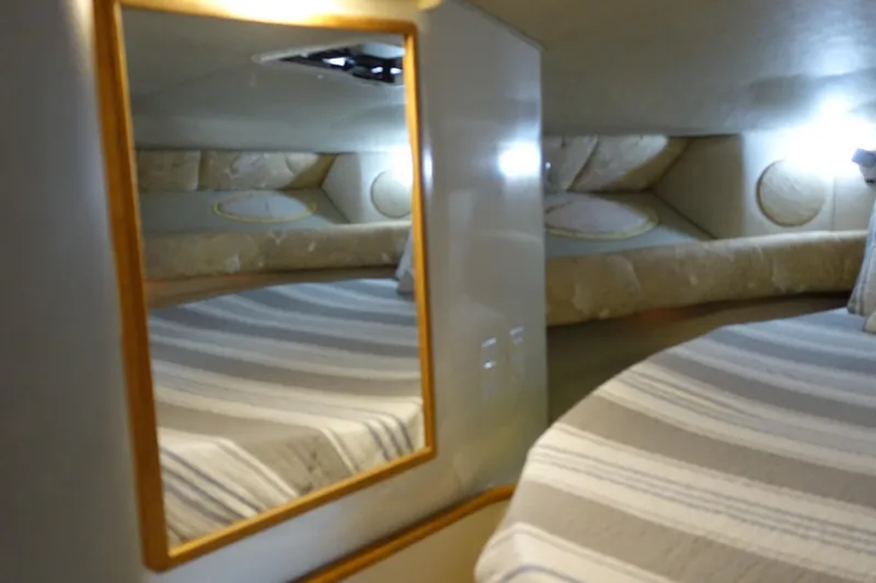 Slide: The Image of Interior cabin of 1996 Sea Ray 370 Sundancer with striped bedding and mirror. - 13