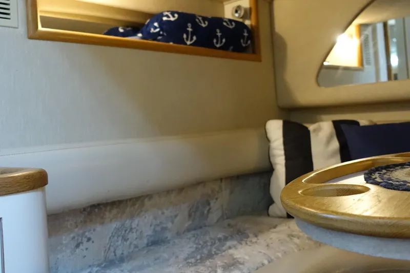 Slide: The Image of Interior of 1996 Sea Ray 370 Sundancer with nautical-themed decor and cozy seating area. - 17