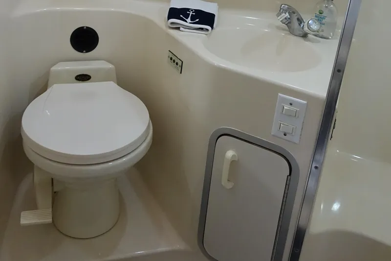 Slide: The Image of 1996 Sea Ray 370 Sundancer bathroom with toilet, sink, and storage cabinet. - 18