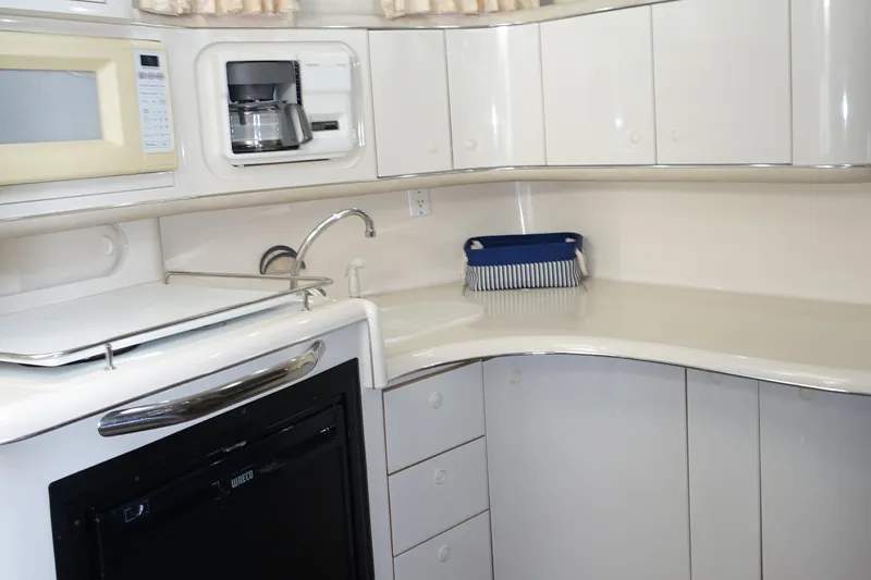 Slide: The Image of 1996 Sea Ray 370 Sundancer yacht kitchen with microwave, coffee maker, and sleek cabinetry. - 7