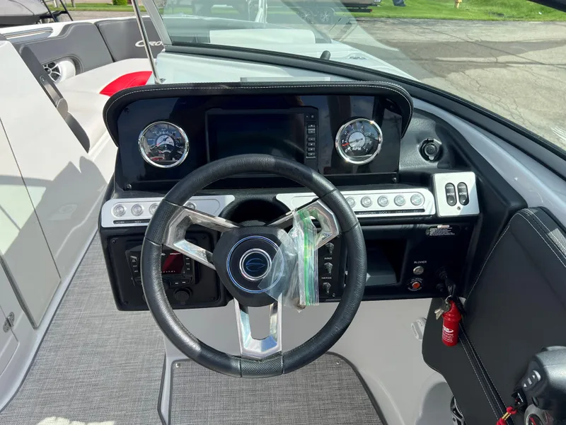Slide: The Image of 2022 Crownline 265 SS boat dashboard with steering wheel and instrument panel. - 8