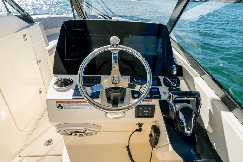 Slide: The Image of 2021 Scout 277 Dorado boat helm with steering wheel and navigation controls. - 10