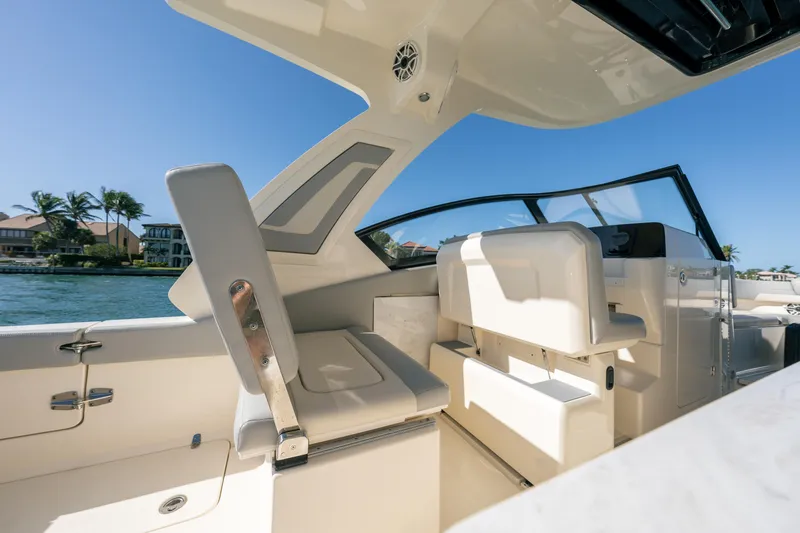 Slide: The Image of 2021 Scout 277 Dorado boat interior with seating and helm, docked by waterfront homes. - 12