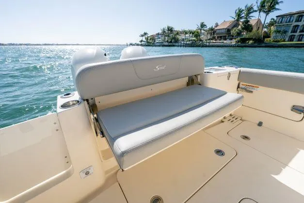 Slide: The Image of 2021 Scout 277 Dorado boat with rear seating, on a sunny waterfront. - 2