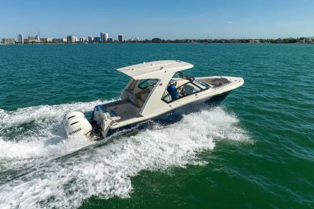 Slide: The Image of 2021 Scout 277 Dorado cruising on open water with city skyline in the background. - 28