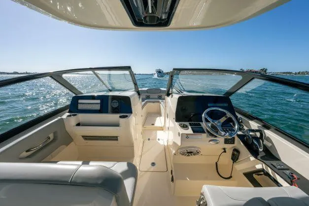 Slide: The Image of 2021 Scout 277 Dorado boat interior with steering wheel and dashboard on open water. - 7