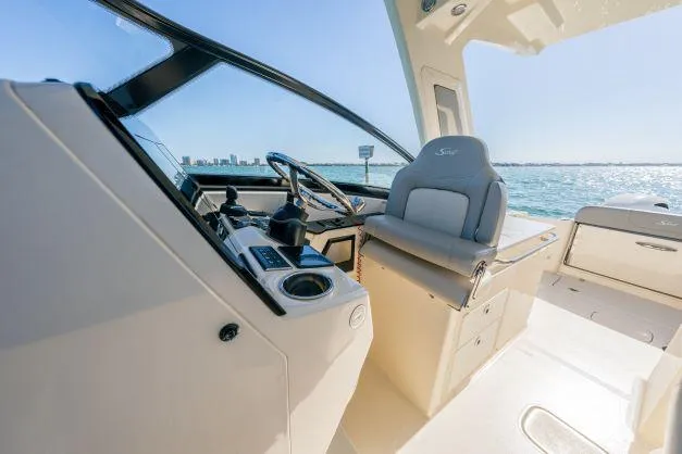 Slide: The Image of 2021 Scout 277 Dorado boat interior with helm and seating, ocean view in background. - 8