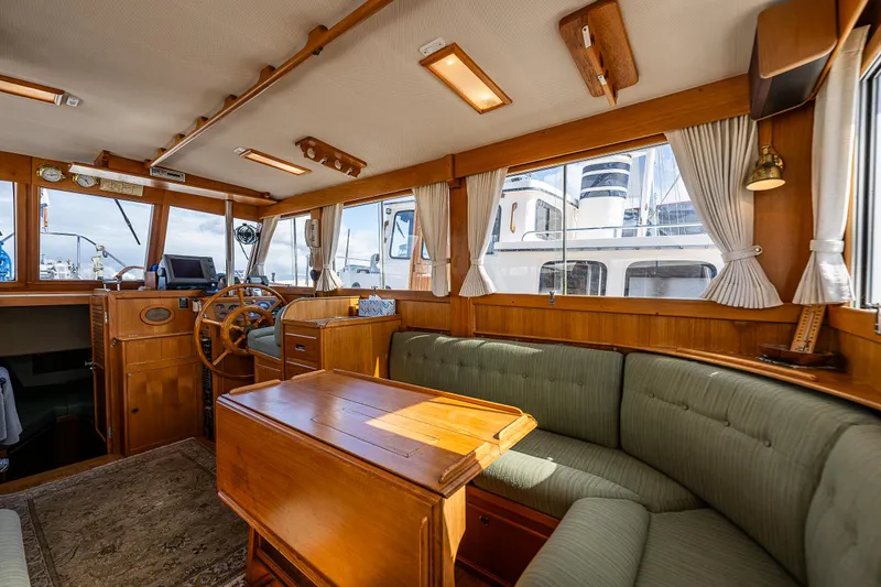 Slide: The Image of 1990 Grand Banks Sedan interior with wooden furnishings and green upholstery. - 17