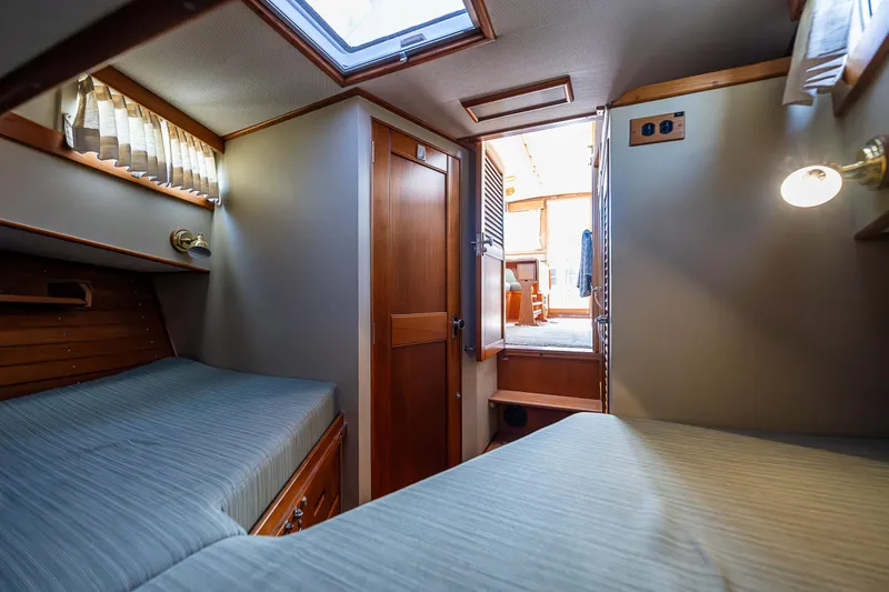 Slide: The Image of 1990 Grand Banks Sedan interior cabin with twin beds and wooden finishes. - 20