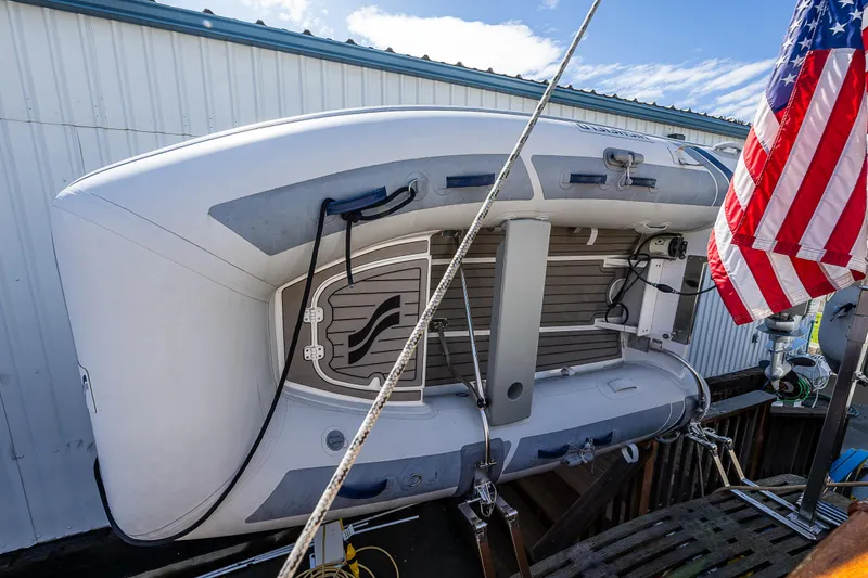 Slide: The Image of Inflatable boat on a 1990 Grand Banks Sedan yacht with American flag. - 21