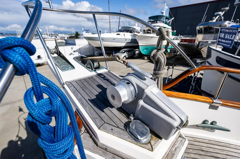 Slide: The Image of 1990 Grand Banks Sedan boat deck with winch and blue rope. - 24