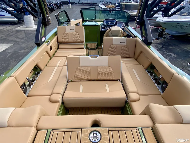 Slide: The Image of 2022 MasterCraft X26 boat interior with tan seating and green accents. - 10