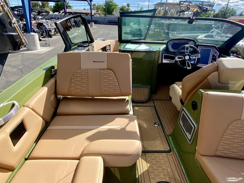Slide: The Image of 2022 MasterCraft X26 boat interior with tan leather seats and green accents. - 11