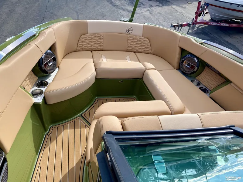 Slide: The Image of 2022 MasterCraft X26 boat interior with tan seating and green accents. - 12