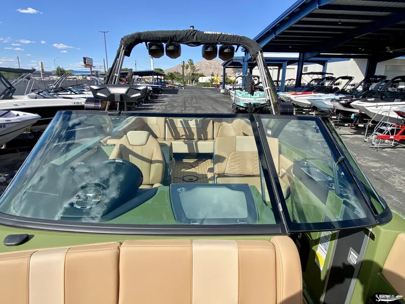 Slide: The Image of 2022 MasterCraft X26 boat interior at a dealership, showcasing seating and dashboard. - 13