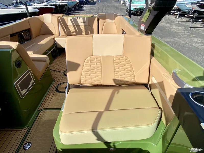 Slide: The Image of 2022 MasterCraft X26 boat interior with tan seating and green accents. - 14