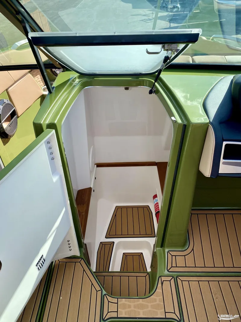 Slide: The Image of 2022 MasterCraft X26 boat interior with open hatch and teak flooring. - 17